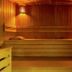 Relax Hôtel Beuzeville Honfleur sauna interior with wooden benches and warm lighting in Honfleur