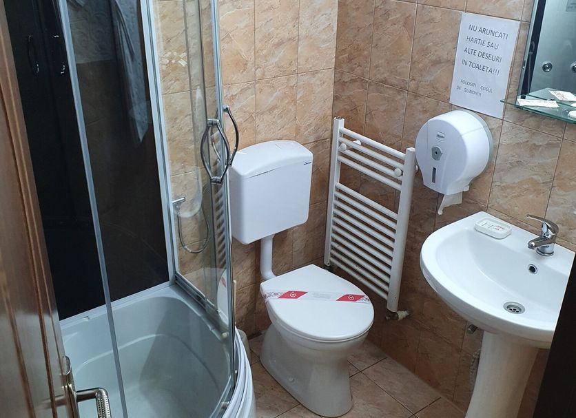 Casa Siady, Vatra Dornei: compact bathroom with shower, toilet, sink, towel rail and tiled walls.