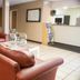 Scottish Inn Downtown Jacksonville lobby with leather chairs, floral seating, and front desk in Jacksonville