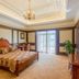 Beijing Jinyu Badaling Resort bedroom with carved wood bed, chandelier and balcony doors in Beijing