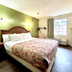 Red Carpet Inn - New Brunswick guest room with bed, green accent wall, window and wall-mounted TV