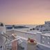 Santorini Mansion at Imerovigli terrace with lounge chairs and sunset sea view in Imerovigli