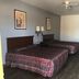 Texas Inn And Suites At La Joya room with two double beds, ceiling fan, and bathroom doorway