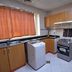 Emirates Stars Hotel Apartments Sharjah kitchen with stove, sink, cabinets and window curtain