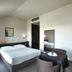 Casalgrande Hotel in Salvaterra guest room with king bed, two chairs, and a small table
