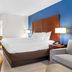Comfort Inn Greenville - Haywood Mall guest room with king bed, TV, desk, and blue accent wall