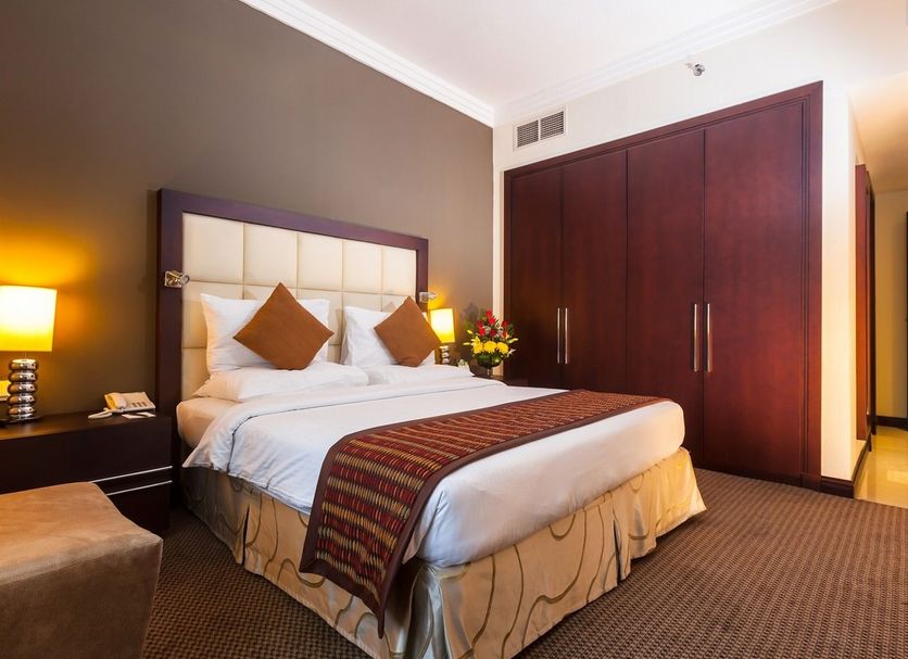 Flora Park Deluxe Hotel Apartments in Dubai guest room with king bed and large wardrobe