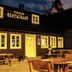 Hotel Viking in Hafnarfjordur with a rustic dark-wood restaurant building and outdoor seating at dusk
