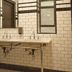 West Village Eurohostel New York bathroom with double sink, subway tile walls, and mirror