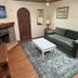 Emerald Bay Lodge South Lake Tahoe living room with stone fireplace, green sofa, coffee table and rug