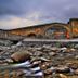 Hotel Grèvol Spa in Llanars beside a stone bridge over a rocky river at dusk