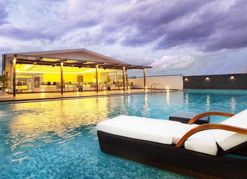 The Grand Magrath Hotel in Bengaluru features a rooftop pool with lounge chairs at sunset.