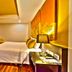 The Heritage Sathorn Suite Hotel Bangkok guest room with king bed, desk, TV and warm wood flooring