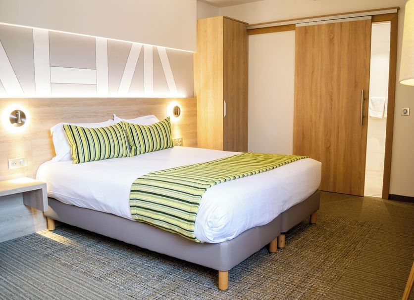 Hôtel Restaurant Au Boeuf in Blaesheim, guest room with striped bedding and sliding wooden closet doors
