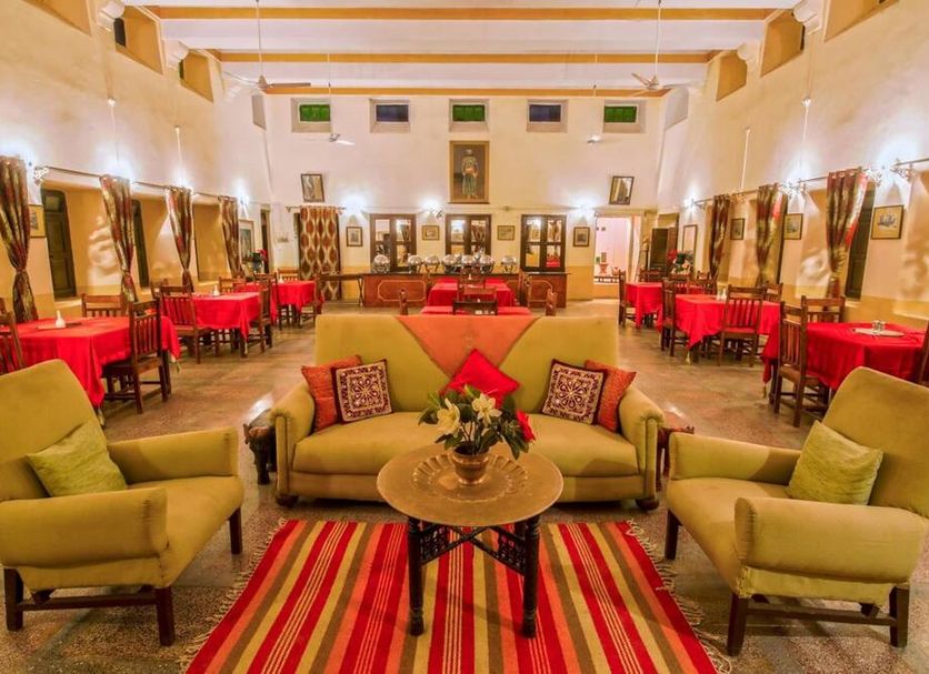 Hotel Ghanerao Castle Ranakpur lounge in Ghanerao with sofas, chairs, and striped rug