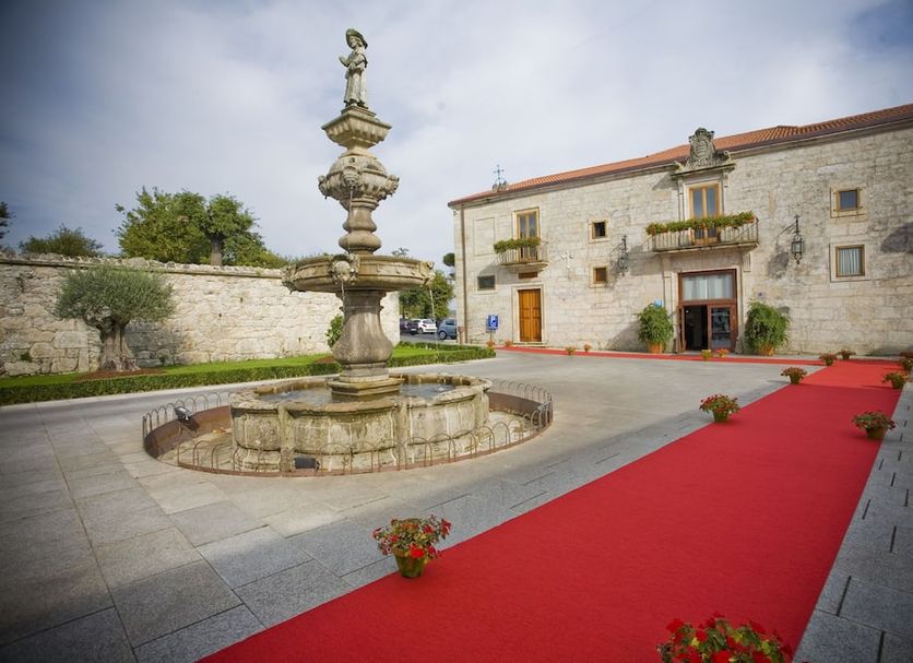 Hotel Pazo de Lestrove by Pousadas de Compostela in Padrón, stone courtyard with fountain and red carpet