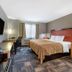 Spark By Hilton Evansville Downtown guest room with king bed, wall-mounted TV, desk, and window