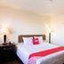 Budgetlodge Oklahoma City guest room with king bed, bedside lamps and red accent bedding