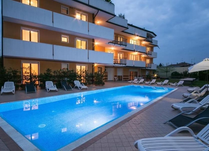 Ferretti Residence Garda Palace in Peschiera del Garda, outdoor pool and sun loungers at dusk