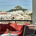 Athenswas Design Hotel Athens terrace with red seating and Acropolis hill view