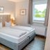 Hotel Herbers Efemir Gmbh guest room in Südbrookmerland with twin bed, window and bedside lamps