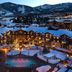 Waldorf Astoria Park City in Park City with snowy mountain views and illuminated outdoor pool at dusk