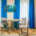 Safrano Palace in Brașov features a round table, four chairs and a wall-mounted TV by bright windows.