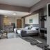 Lym Flat Hotel in Uberlândia guest room with two beds, kitchenette bar, and sitting area