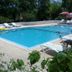 Fire pansiyon in Cirali: outdoor swimming pool with lounge chairs and umbrellas