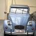 Hotel Colvenier in Antwerp with a vintage blue car parked indoors beside another vehicle.