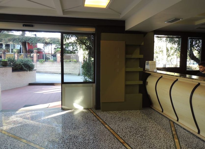 Hotel Zeus Pompei lobby with reception desk, entry doors, and view to the outside