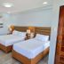 Marvin's Seaside Inn Naval twin guest room with two beds, bedside lamps, and wood-look flooring