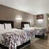 Red Roof Inn Hartford - New Britain guest room with two beds, wall lamps, and wood-look flooring