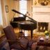 1842 Inn in Macon: elegant lounge with grand piano, lit fireplace, coffee table and armchairs