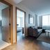 The Preston House and Hotel in Riverhead: modern suite with living area, bedroom, and large windows.