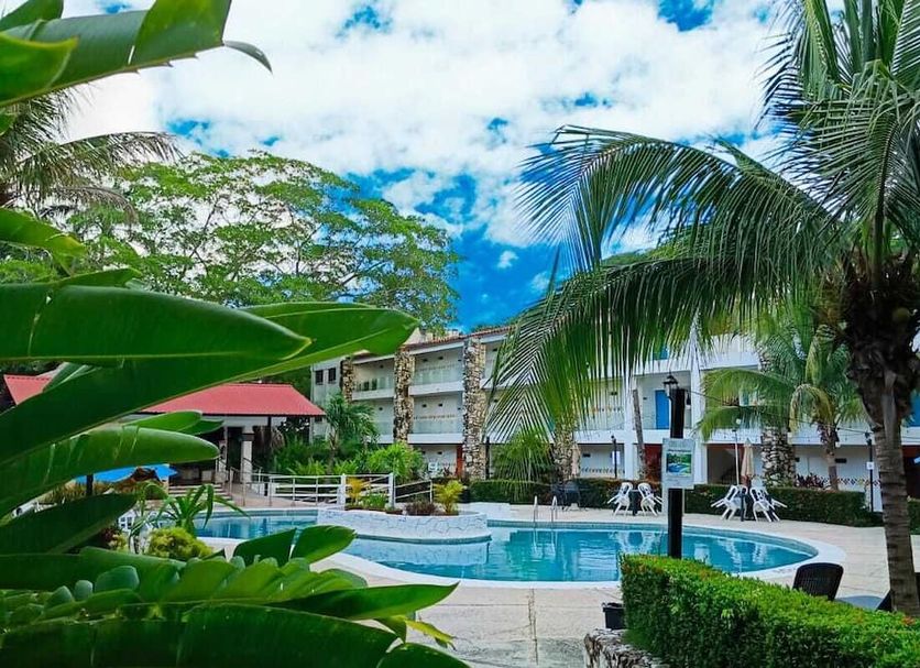 Hotel Plaza Palenque in Palenque with a tropical pool area and palm trees under a bright sky