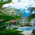 Hotel Plaza Palenque in Palenque with a tropical pool area and palm trees under a bright sky