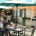 Guests dining outdoors at Inn at Tamarind Court in St. John under large teal umbrellas