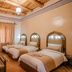 Kasbah Tizzarouine, Boumalne Dadès: guest room with three twin beds and woven ceiling