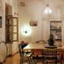 City Circus Athens dining room with long wooden table, chandelier, bookshelves and open French doors