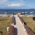 Cunda Basel Otel in Ayvalik with seafront lawn, walkway to beach, loungers, and umbrellas