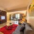 Sand & Sandals Desaru Beach Resort & Spa suite in Bandar Penawar with sofa, TV, and sea-view balcony