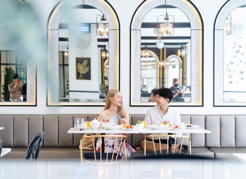 Ratri Hotel Phuket Old Town in Phuket City: guests dining in an elegant restaurant with arched mirrors