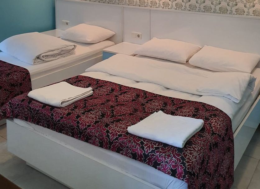 Tulip Guesthouse in Istanbul room with a double bed and single bed, both made with folded towels