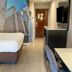 Clarion Pointe Atlanta Airport College Park room with bed, TV, desk and cityscape wall mural