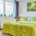 Hotel Stadt Mühlhausen room with green bedspread, forest wall art, and window by the bed in Mühlhausen