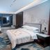 Zhongyuan Hotel in Anyang guest room with king bed, city-view window, and modern seating area