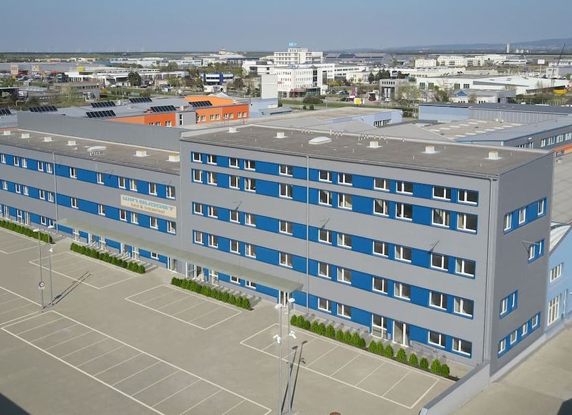 WinBudget 'bed&breakfast' in Wiener Neustadt, exterior of modern blue-gray hotel with parking lot