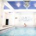 Indoor pool at Grande Hotel e Termas de Araxá in Araxá with white tiled walls and blue ceiling