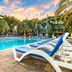Mizner Place at Weston Town Center pool deck with lounge chairs and palm trees in Weston